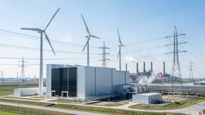 Site industriel moderne avec un électrolyseur alimenté par des éoliennes et des lignes électriques, une usine sidérurgique visible en arrière-plan sous une lumière naturelle éclatante.